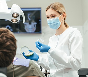 Dentist showing patient clear aligner in treatment room