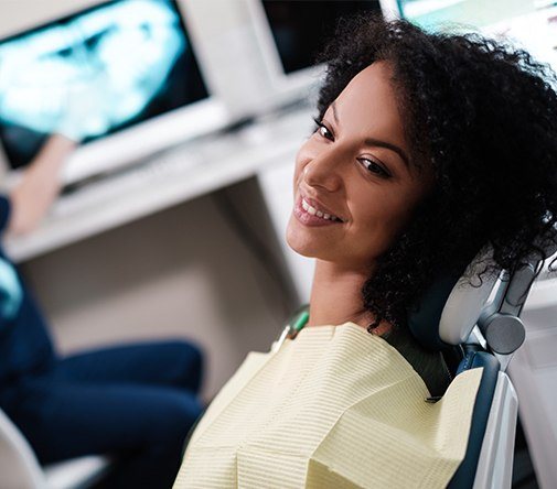 woman with curly hair laying back in exam chair