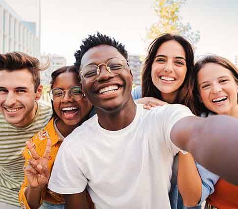 Patient in Marysville with dental implants smiling with friends